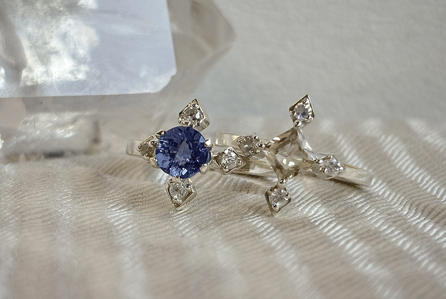 compassシリーズより、ブルーのカラーチェンジフローライトが中石のCelestiaとシャンパンカラーのオレゴンサンストーンが中石のLuciaが二つ並んでいる写真。