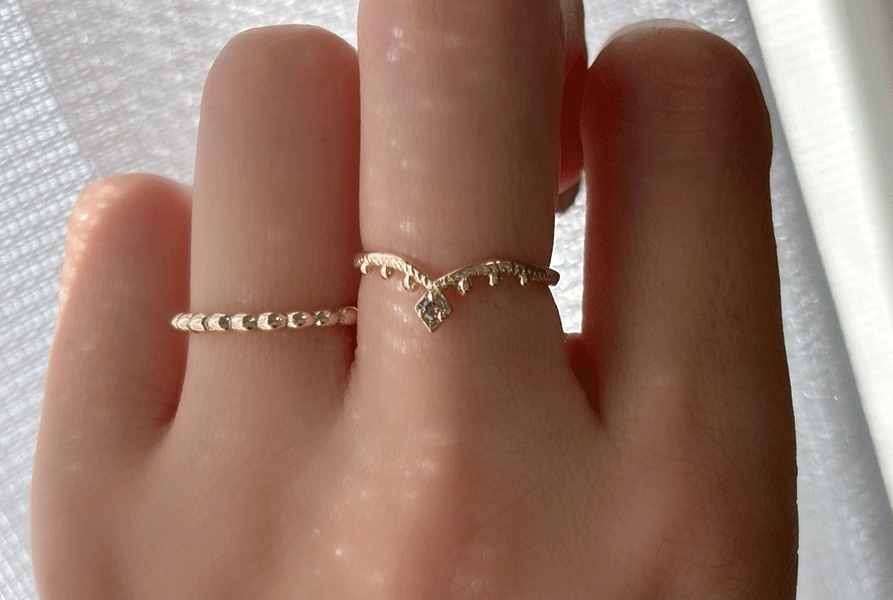 K10製のブラウンダイヤが輝く指輪、Veiled TikkaEllipse Harmonyを中指と薬指に着用している写真